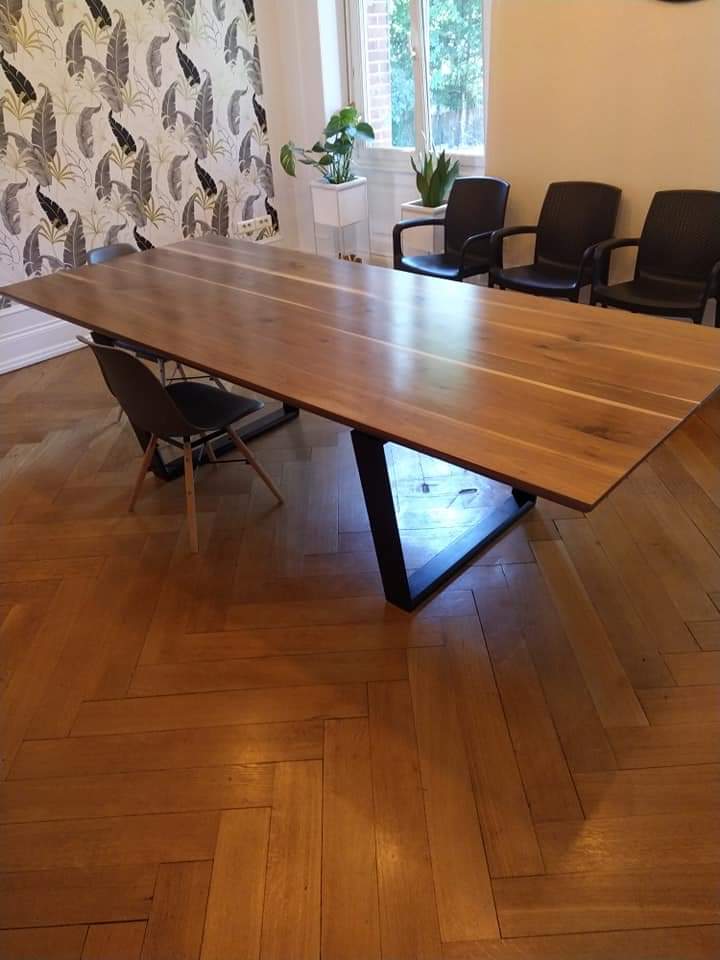 Table de salle à manger en bois de noyer US. Plateau vernis satin. Piètement en frêne laqué noir.